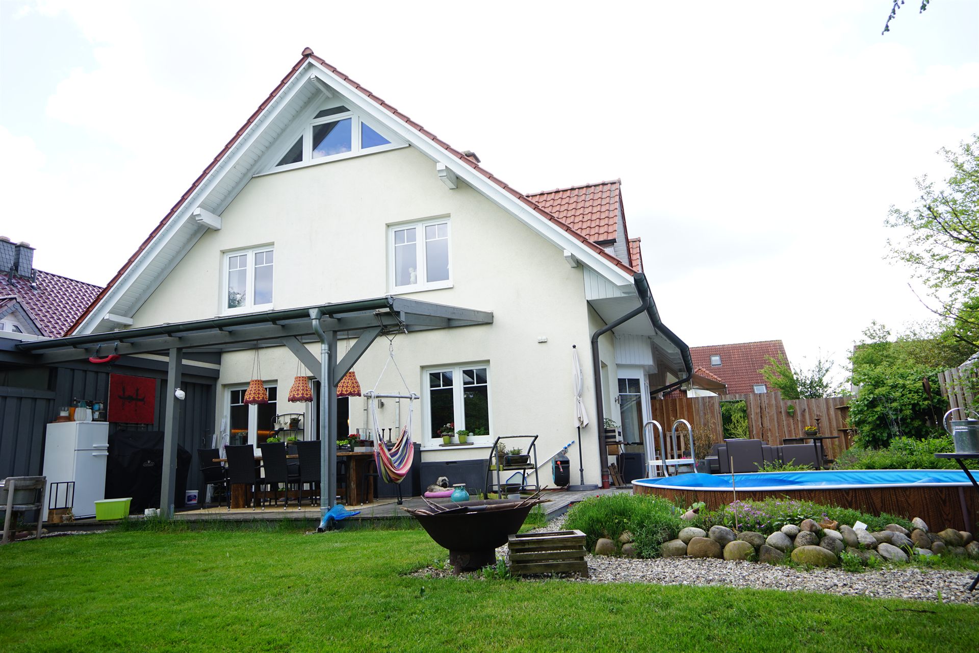 Hausansicht vom Garten mit überdachter Terrasse
