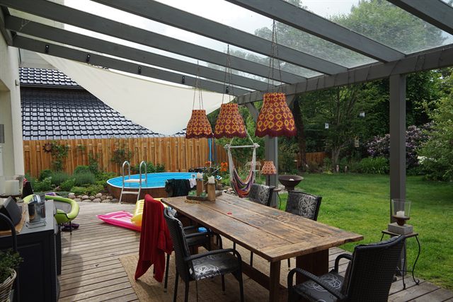 Glasüberdachte Terrasse mit Esstisch
